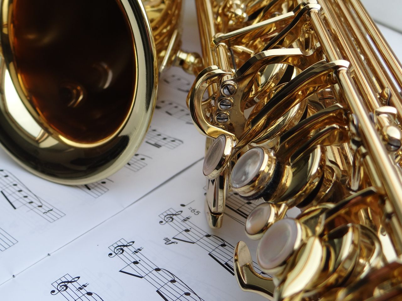 Elegant saxophone resting on sheet music, showcasing its shiny brass details.