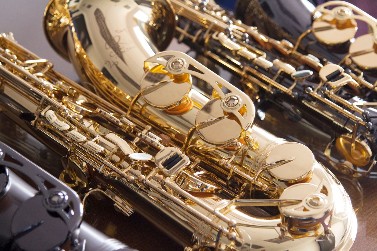 Detailed close-up of shiny brass saxophones arranged in a London music studio.